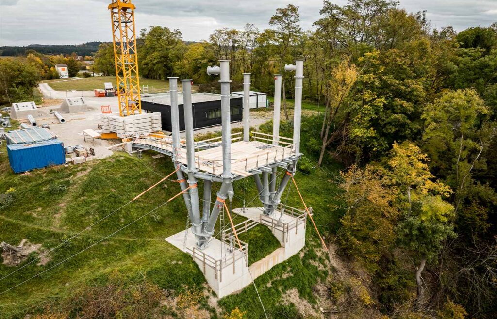 Nahaufnahme einer Stahlkonstruktion am Hang vor einem Baufeld