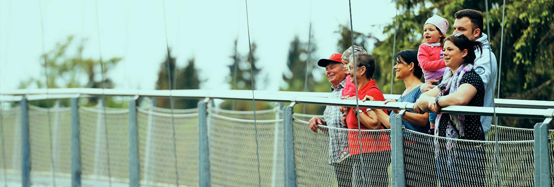 Eine Gruppe von Menschen steht auf einer Hängebrücke