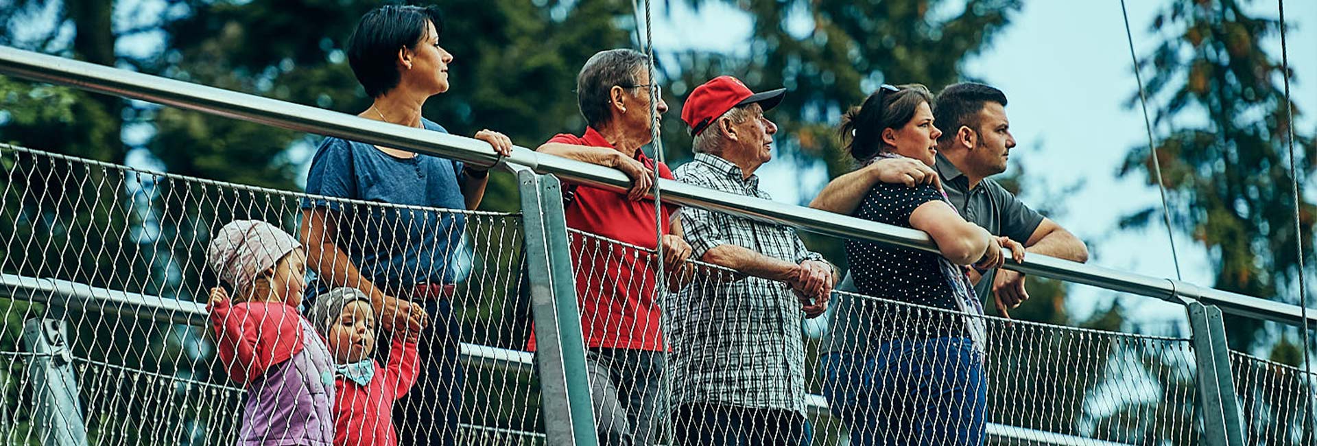 Eine Gruppe von Menschen steht auf einer Hängebrücke