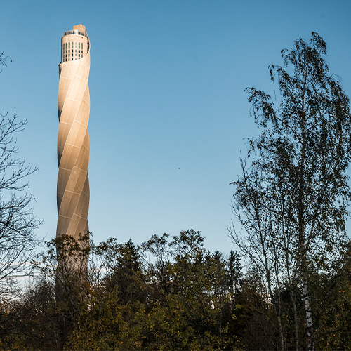TK elevator Testturm mit Bäumen im Vordergrund