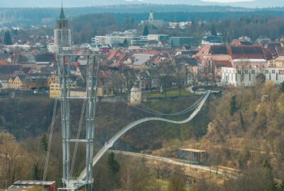 Abbildung einer Hängebrücke mit Altstadt im Hintergrund