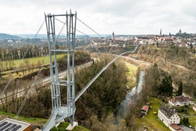Abbildung einer Hängebrücke mit Altstadt im Hintergrund