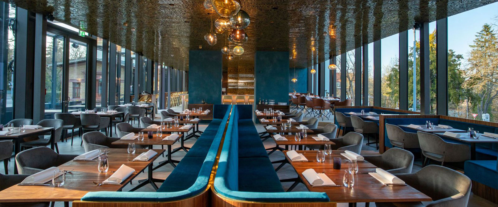 innnenansicht in einen großen restaurantsaal im art deco stil mit vielen fenstergläsern