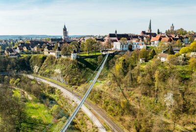 Abbildung einer Hängebrücke mit Altstadt im Hintergrund