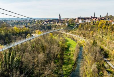 Abbildung einer Hängebrücke mit Altstadt im Hintergrund