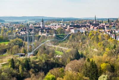 Abbildung einer Hängebrücke mit Altstadt im Hintergrund