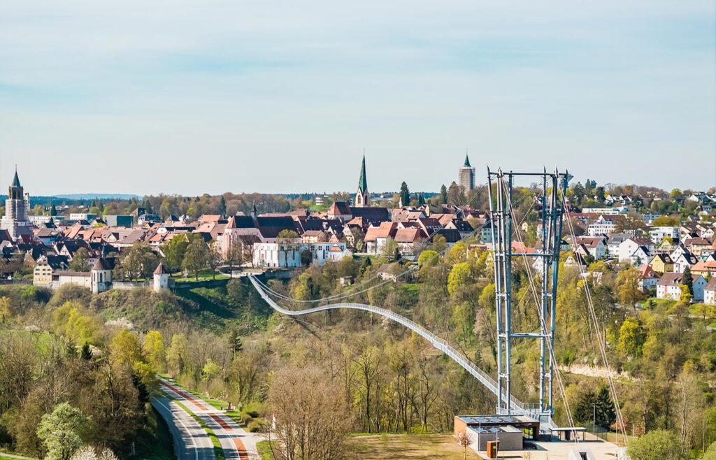 Abbildung einer Hängebrücke mit Altstadt im Hintergrund