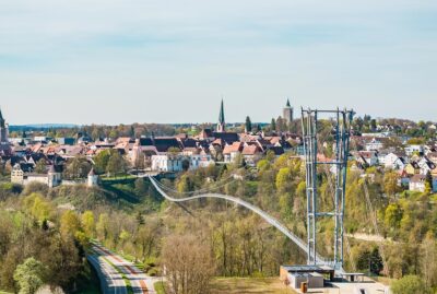 Abbildung einer Hängebrücke mit Altstadt im Hintergrund