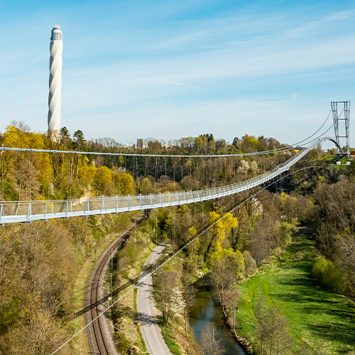 Abbildung einer Hängebrücke mit Testturm im Hintergrund.