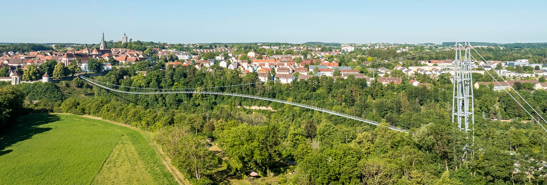 Abbildung einer Hängebrücke mit Altstadt im Hintergrund
